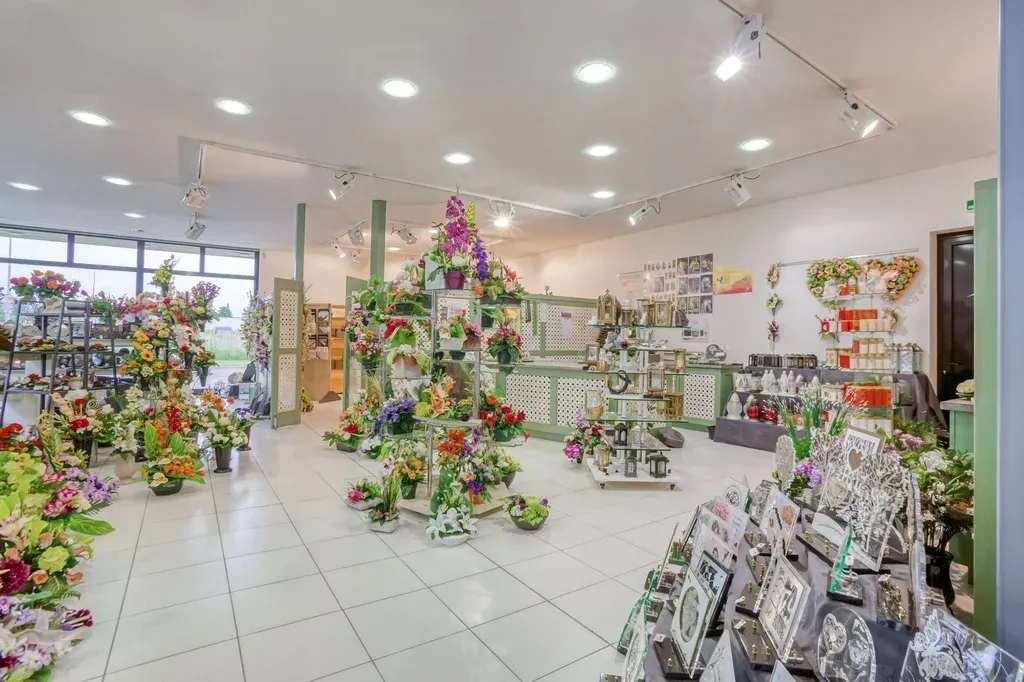 Vue d'ensemble de la boutique de pompes funèbres avec fleurs et ornements.