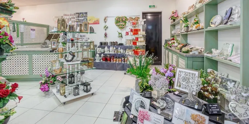 Interieur d'un magasin d'articles funeraires avec fleurs et plaques.