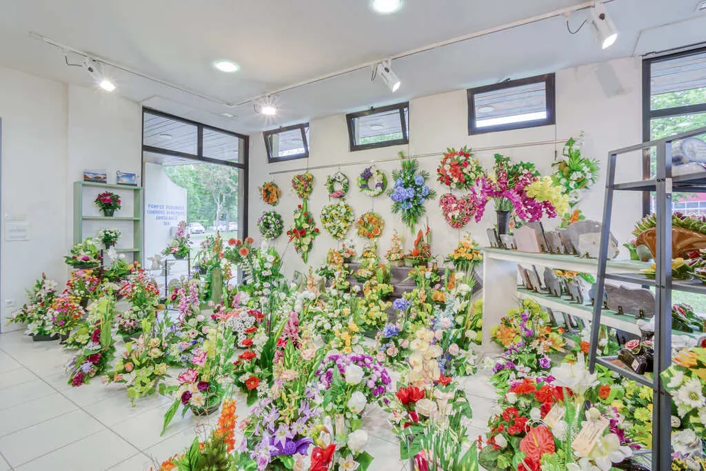 Grand choix de compositions florales artificielles pour obsèques en magasin.