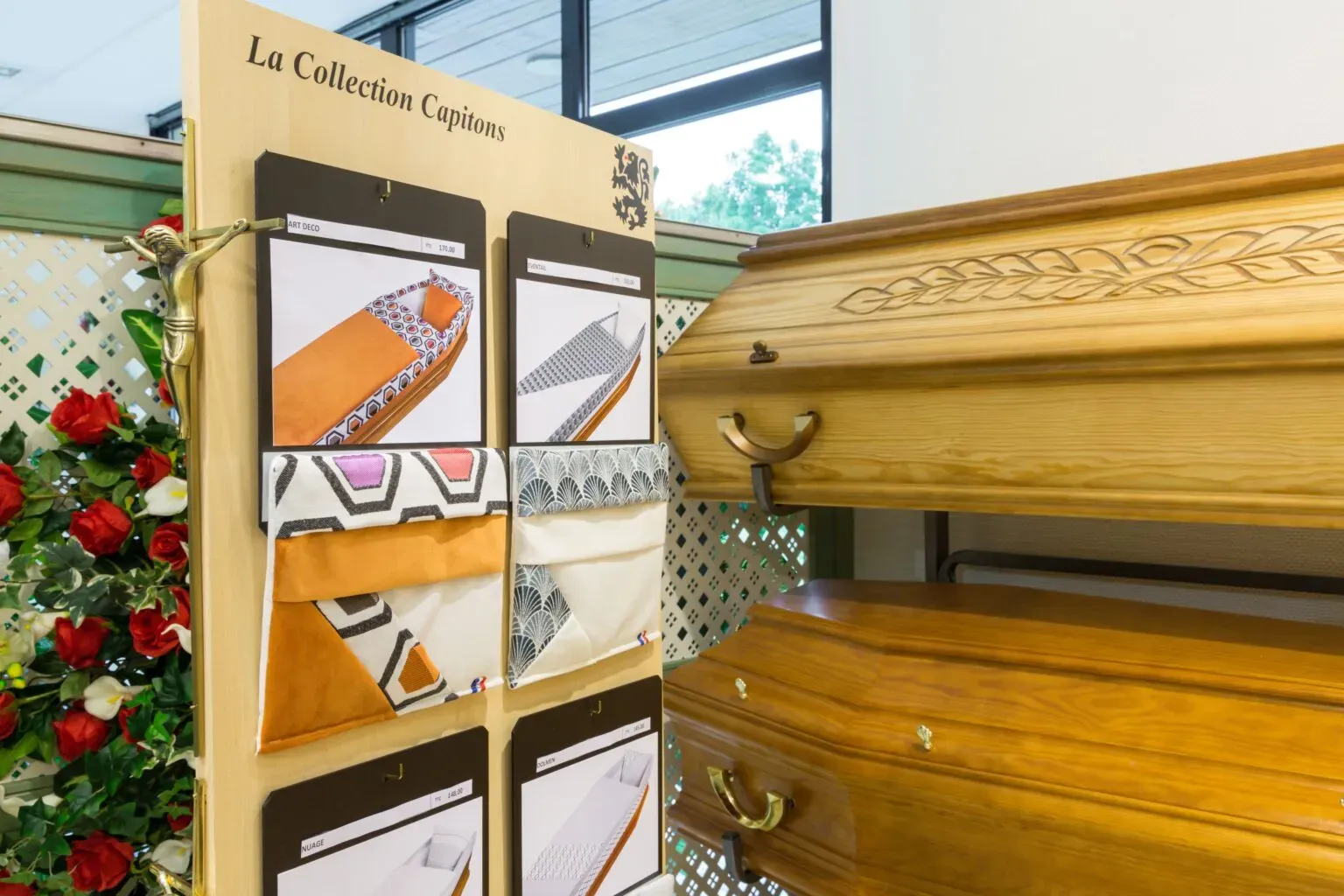 Cercueils en bois et nuancier de tissus de capitonnage en agence.