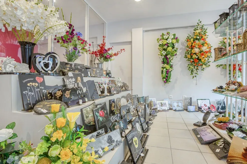 Exposition de plaques funeraires personnalisees et de fleurs de deuil.