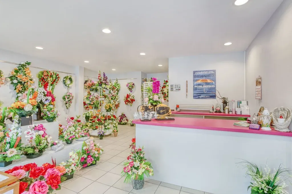 Accueil et comptoir d'une agence de pompes funebres avec compositions florales.
