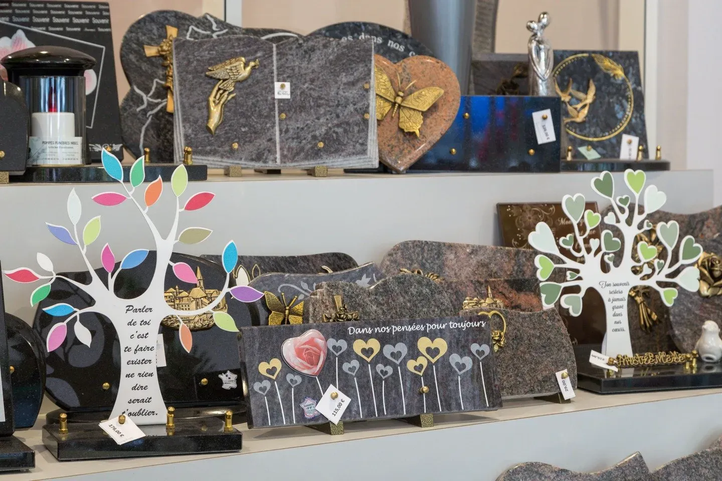 Plaques souvenir et ornements funebres personnalisés exposés en boutique.
